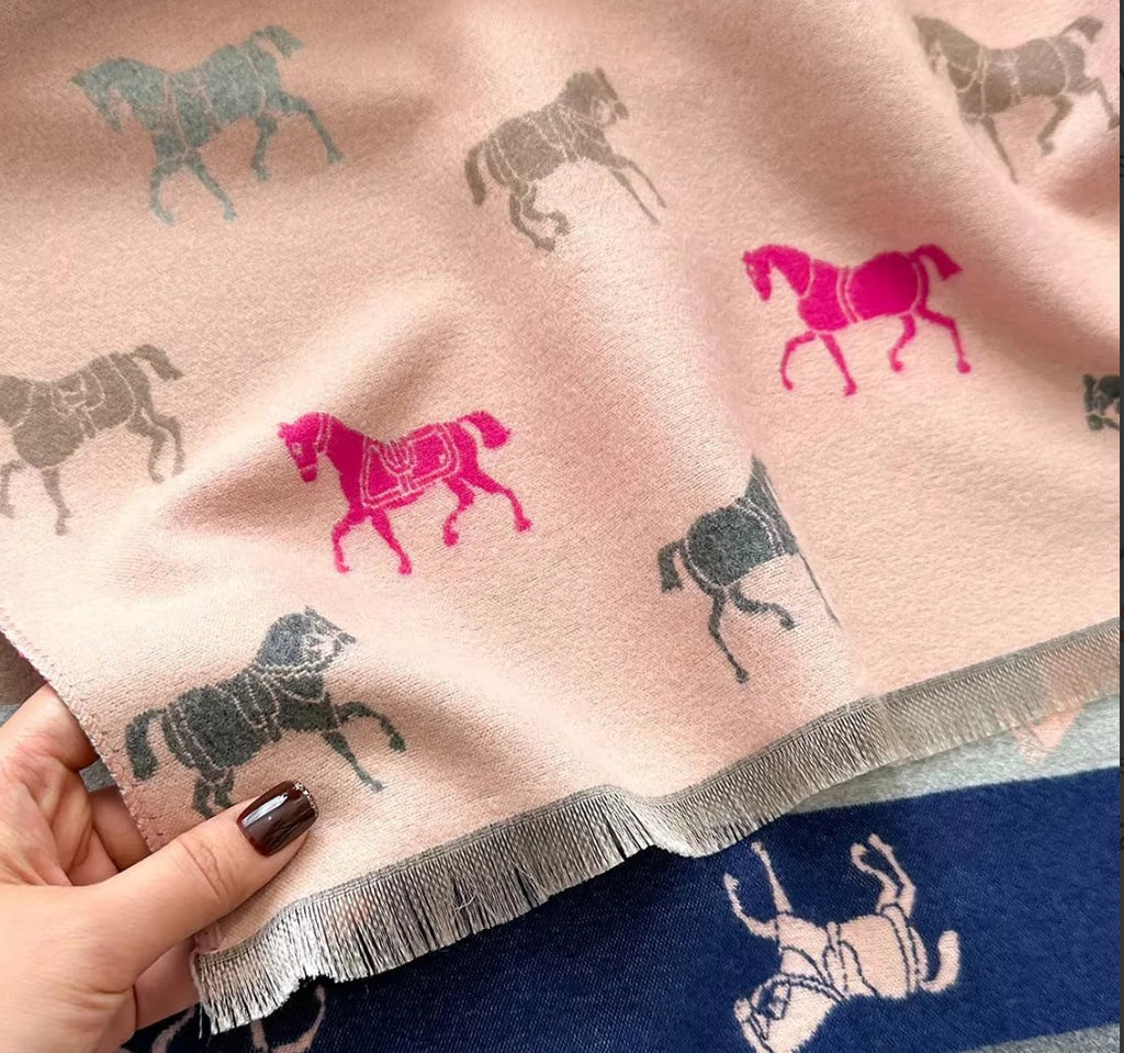 Woman wearing blush pink reversible horse print winter scarf with fringe detail