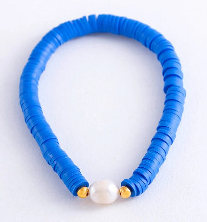 Cobalt blue heishi bead stretch bracelet featuring a freshwater pearl centrepiece with gold accent beads.