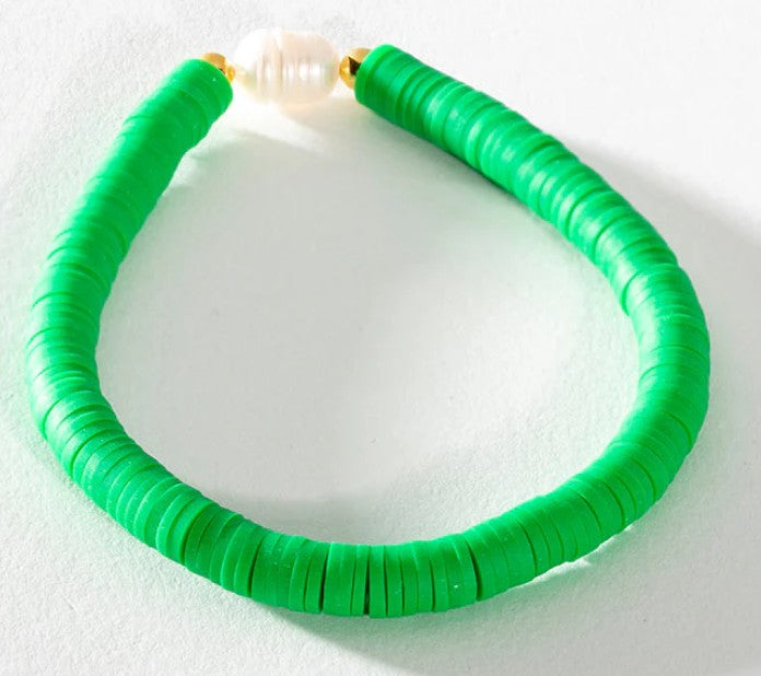 Bright green heishi bead stretch bracelet featuring a freshwater pearl centrepiece and gold accent beads.