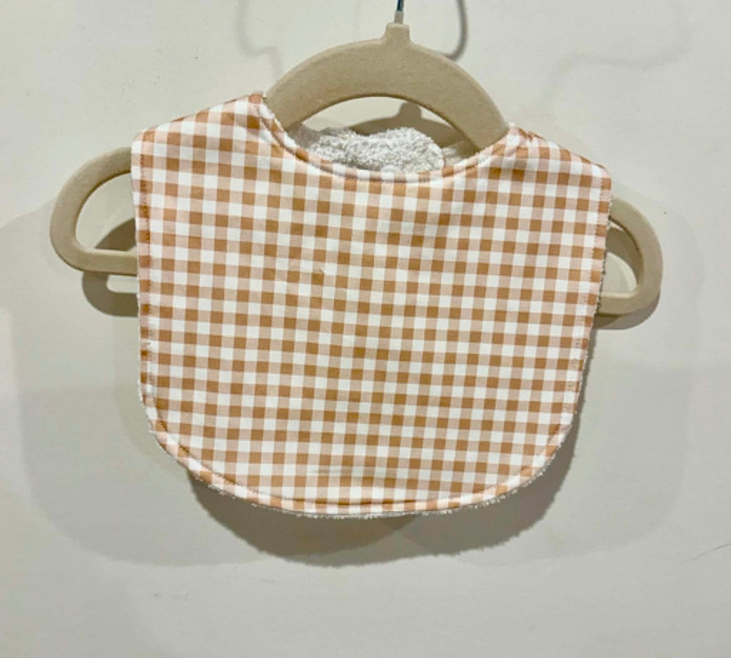Brown gingham baby bib on wooden hanger