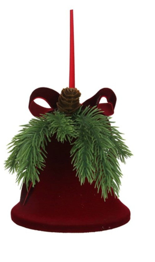 A red velvet Christmas bell ornament with a red hanging rod, green pine branches, and a red bow, isolated on a white background.