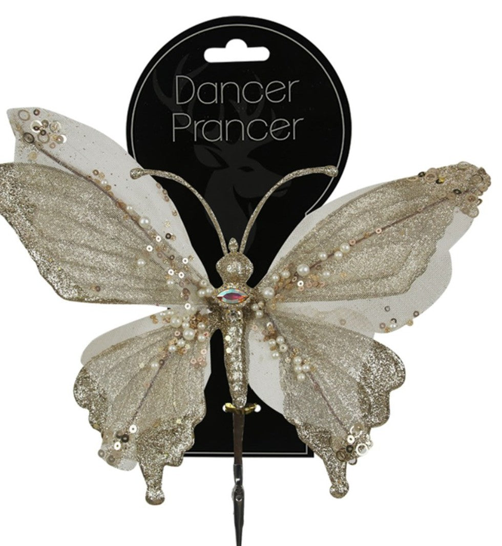 A glittery silver and white butterfly hair pin with rhinestones and sequins, attached to a black circular card labeled 'Dancer Prancer'.
