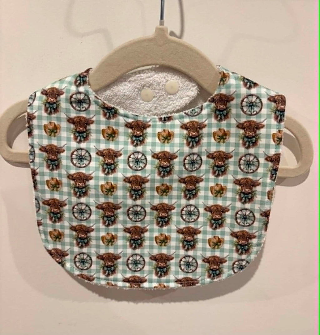 Green gingham baby bib with highland cows and cowboy details