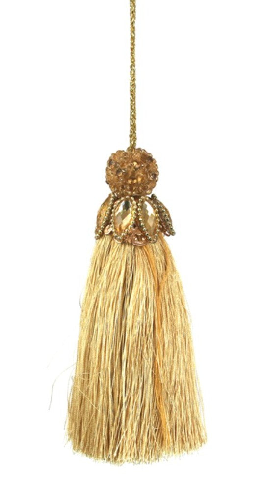 A decorative gold tassel ornament with a textured beaded top and a long fringe tassel, hanging against a plain white background.