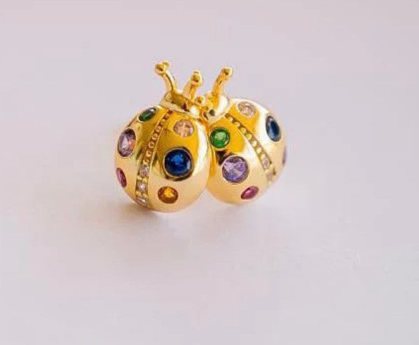 Gold plated sterling silver ladybug stud earrings with colourful enamel and crystal accents, suitable for sensitive ears.