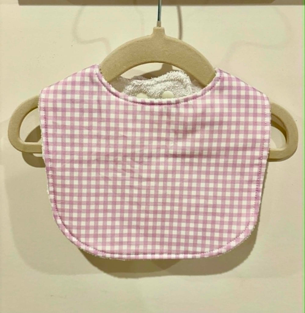 Pale mauve gingham baby bib on wooden hanger