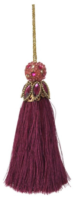 A decorative tassel ornament with a deep burgundy thread body, a gold-toned beaded cap, and pink rhinestone accents, hanging against a plain white background.