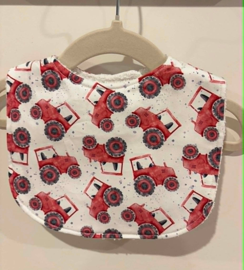 White baby bib with red tractor print