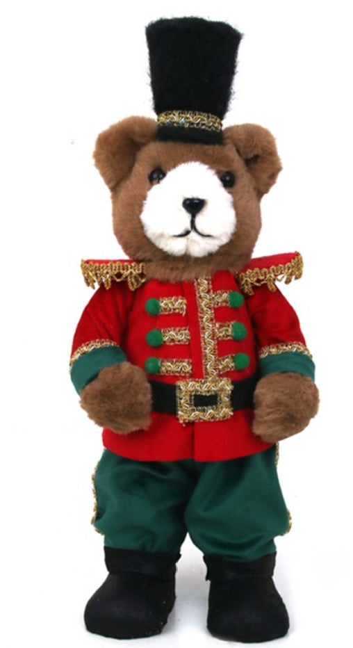 A plush teddy bear dressed in a red and green nutcracker-style military uniform with gold trim, a black top hat, and black boots, shown against a plain white background.