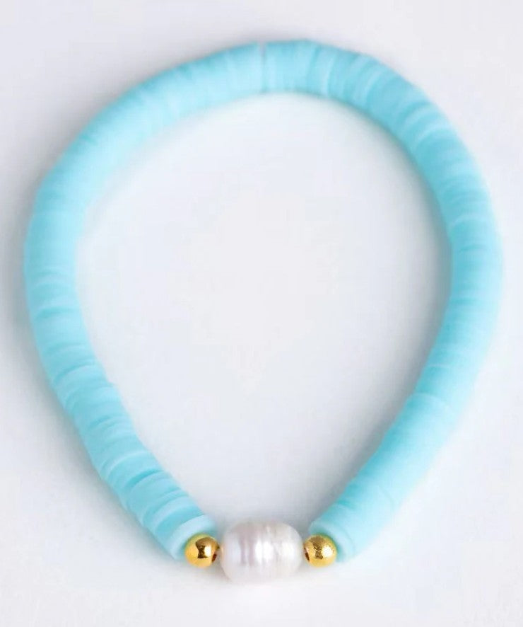 Baby blue heishi bead stretch bracelet featuring a freshwater pearl centrepiece and gold accent beads.